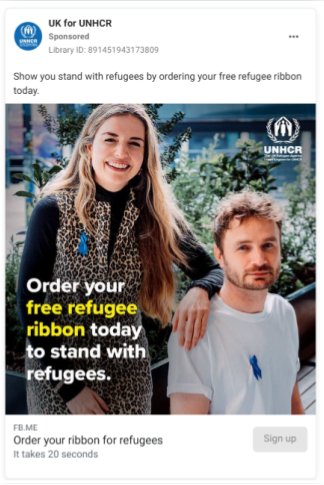 Screenshot of UK for UNHCR Meta ad on Facebook, which reads Show you stand with refugees by ordering your free refugee ribbon today. It has an image of two people, a smiling woman standing next to a sitting man, both wearing a blue ribbon. There is a caption on the photo that reads, Order your free refugee ribbon today to stand with refugees.